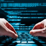 Hacker using laptop. Lots of digits on the computer screen.